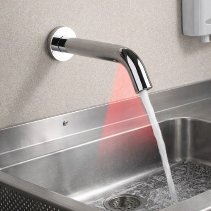 Wall mounted touchless faucet installed above a commercial sink